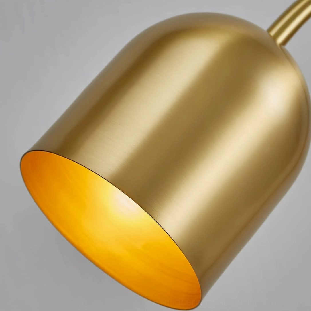 Close-up detail of brass gooseneck lamp shade showing brushed gold exterior and warm golden inner lining