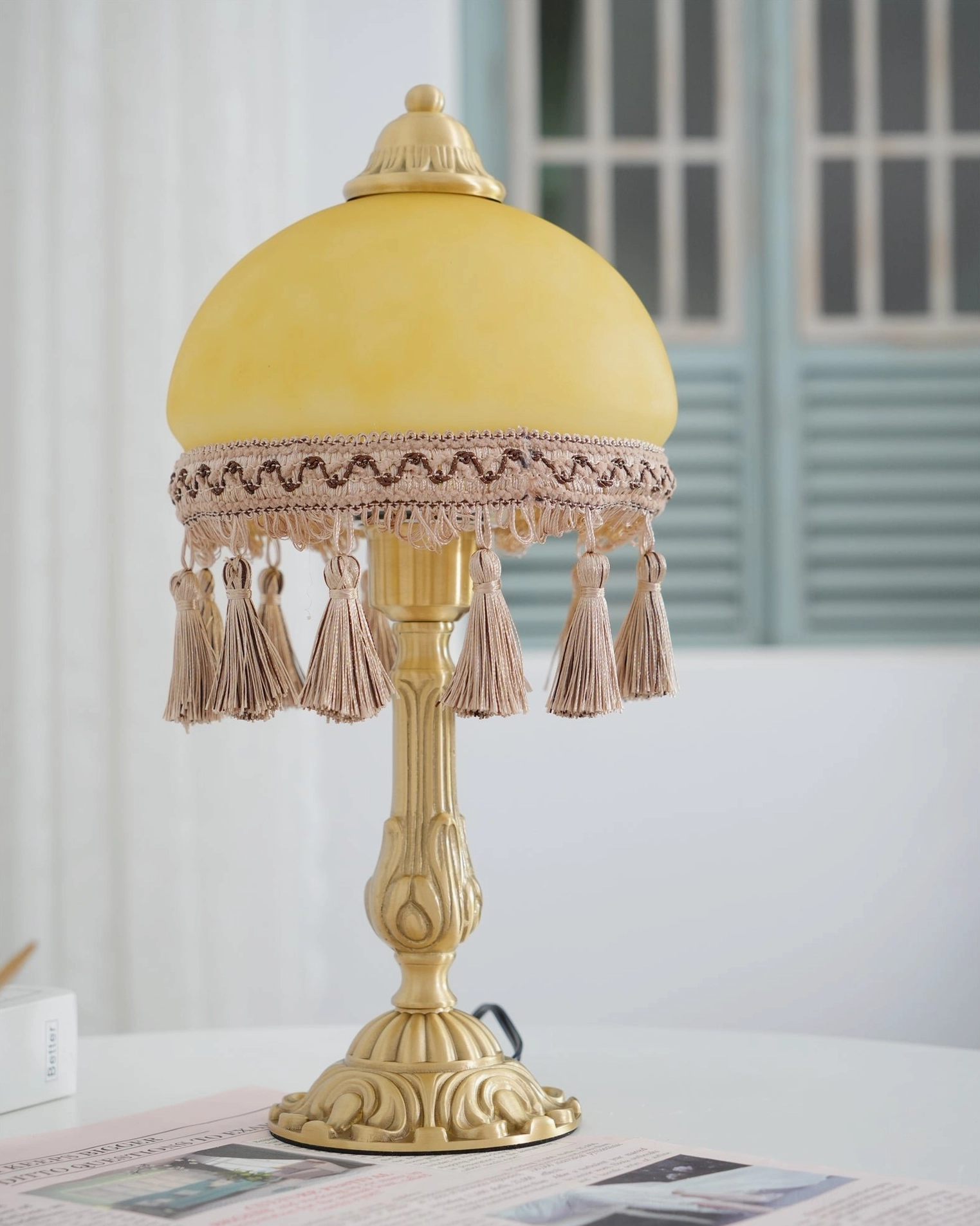 Brass table lamp tassel trim and dome shade in warm yellow and brown tones