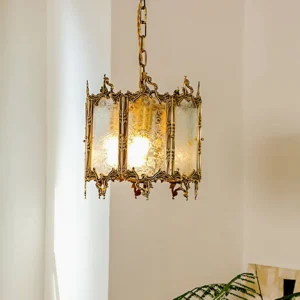 Brass lantern pendant fixture close-up detail showing ornate metal trim, frosted glass construction, and warm glowing light interior