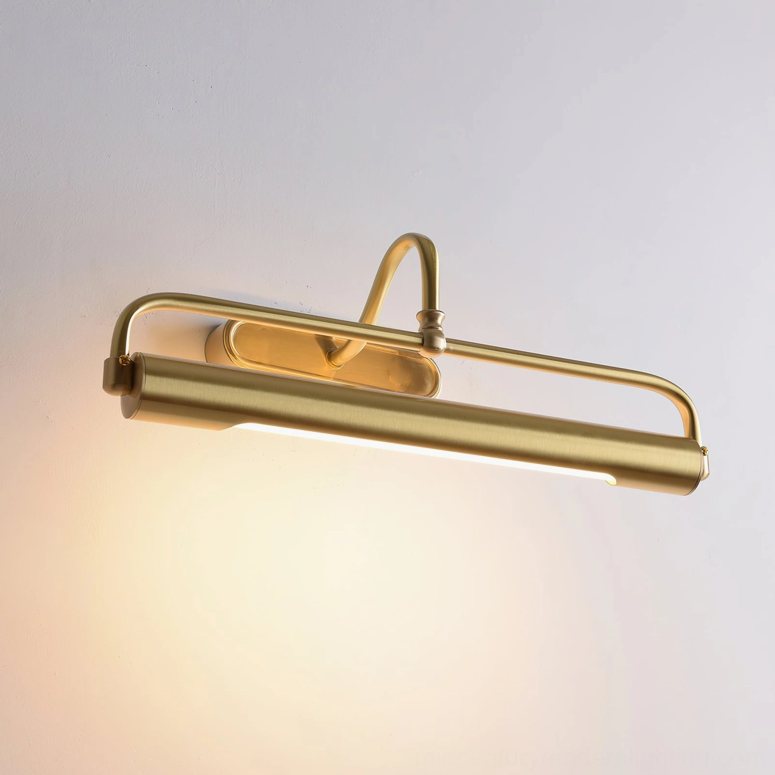 Close-up detail of brass gooseneck sconce light head with warm LED glow, side view