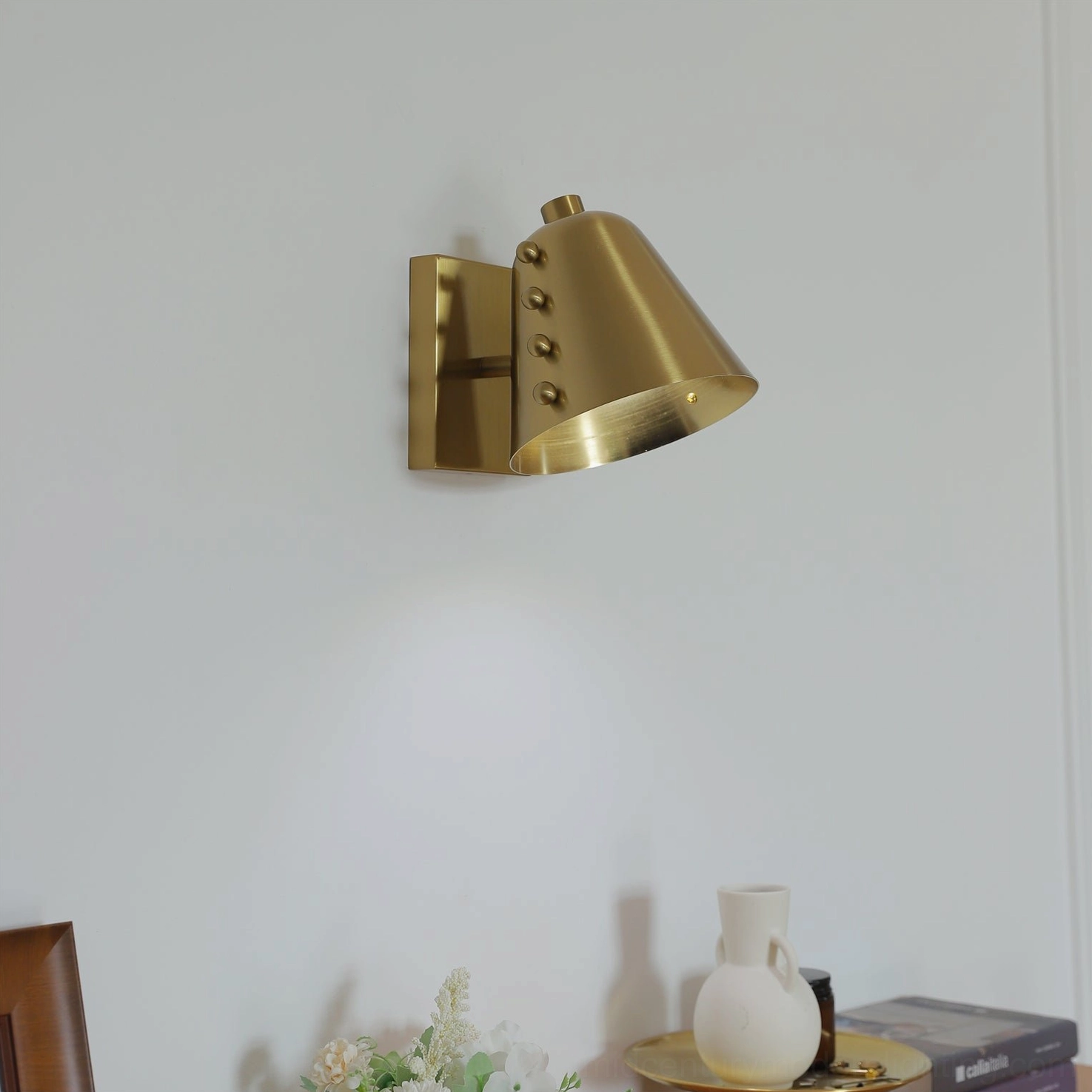 Mid-century modern brass wall sconce side view in dining room with warm ambient lighting and adjustable angle