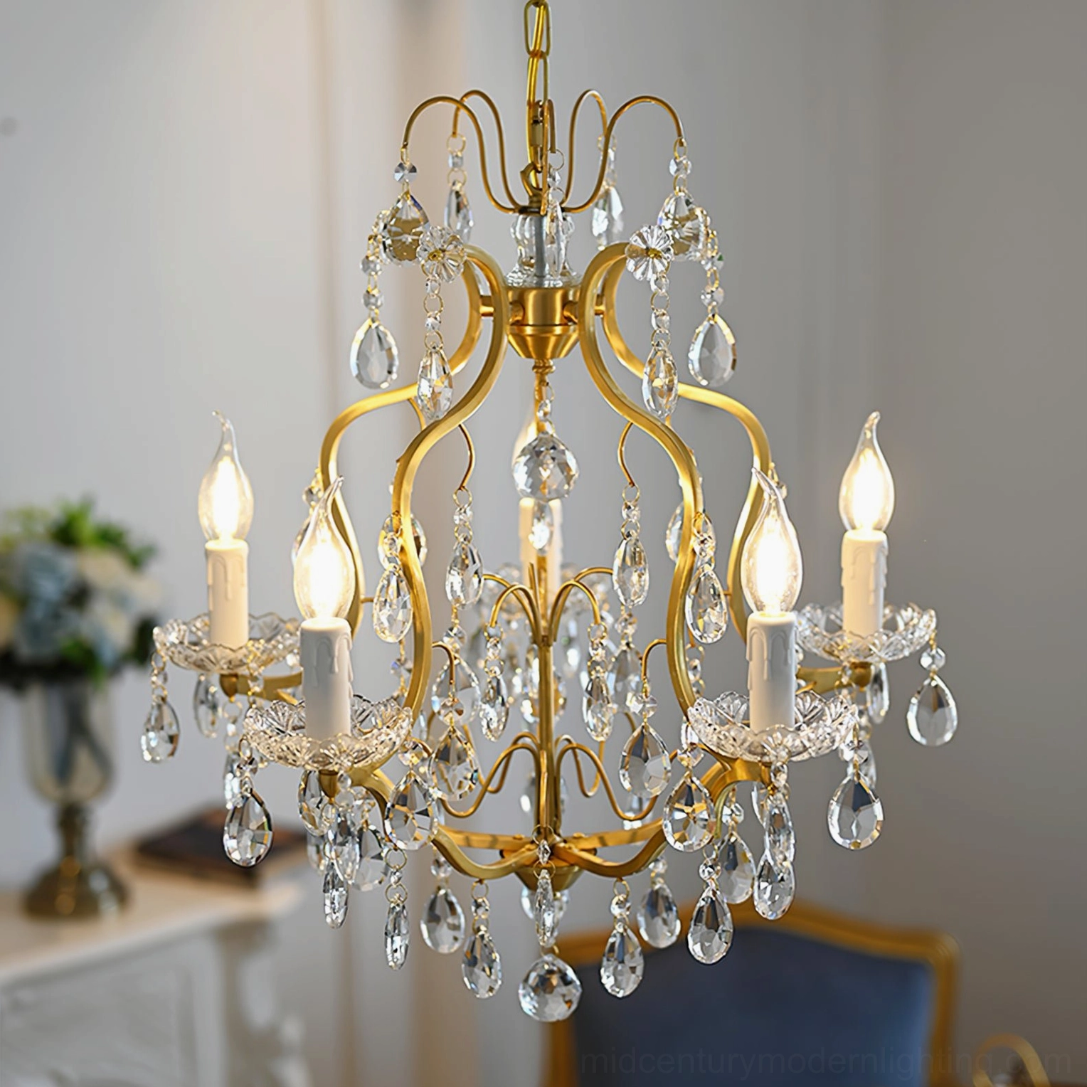 Elegant brass crystal chandelier illuminated in luxury living room interior with warm candlelight glow
