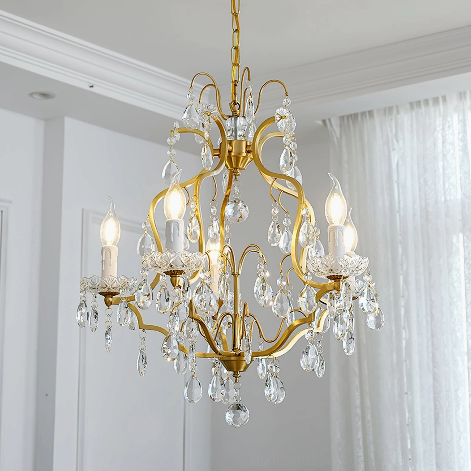 Intricate scroll metal frame brass chandelier with dense hanging crystals and warm bulb illumination