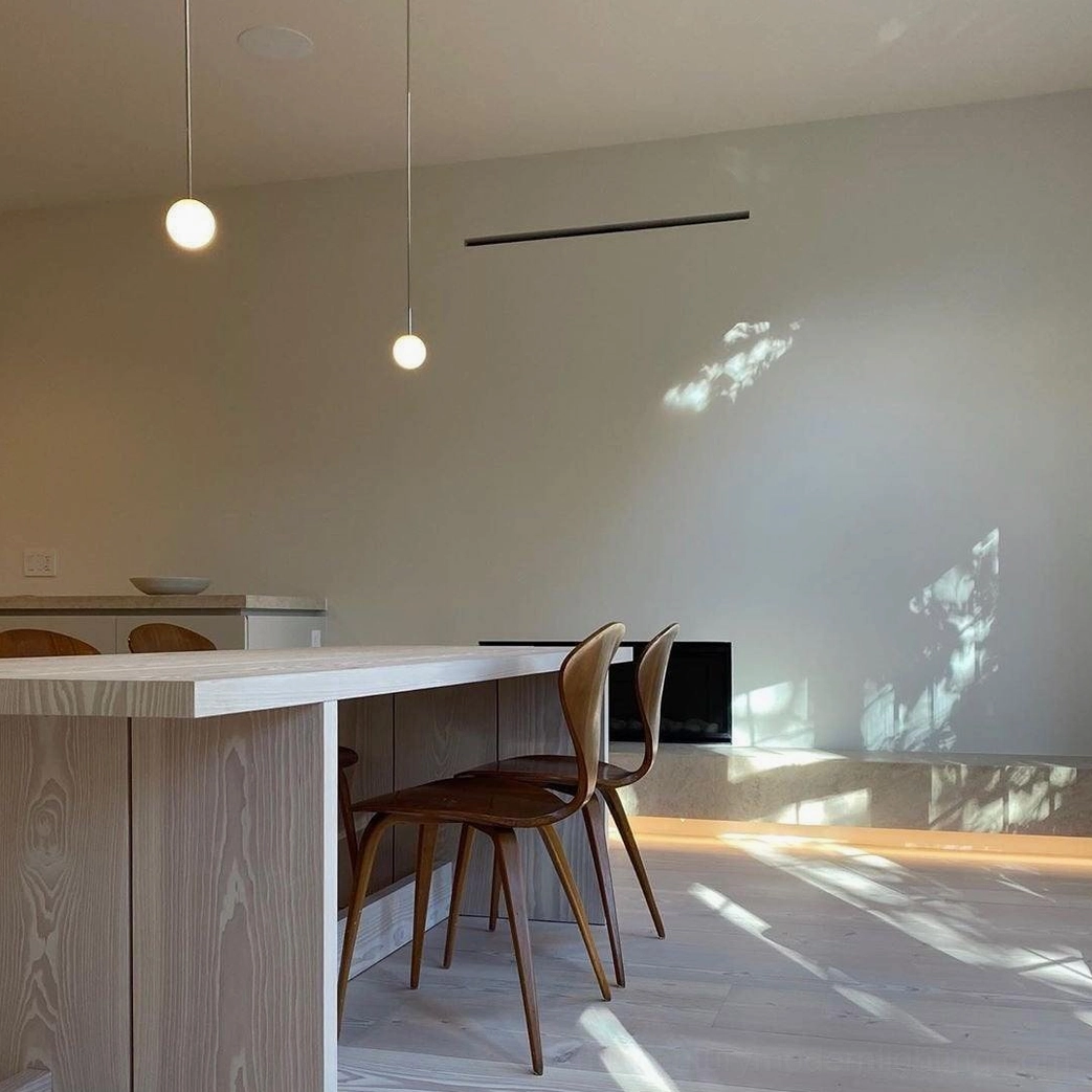 Brass suspension pendant light fixture creating soft diffused illumination in modern interior