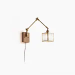 Dual-arm mid-century modern swing wall lamp with brass hardware and ribbed glass shade, front studio view