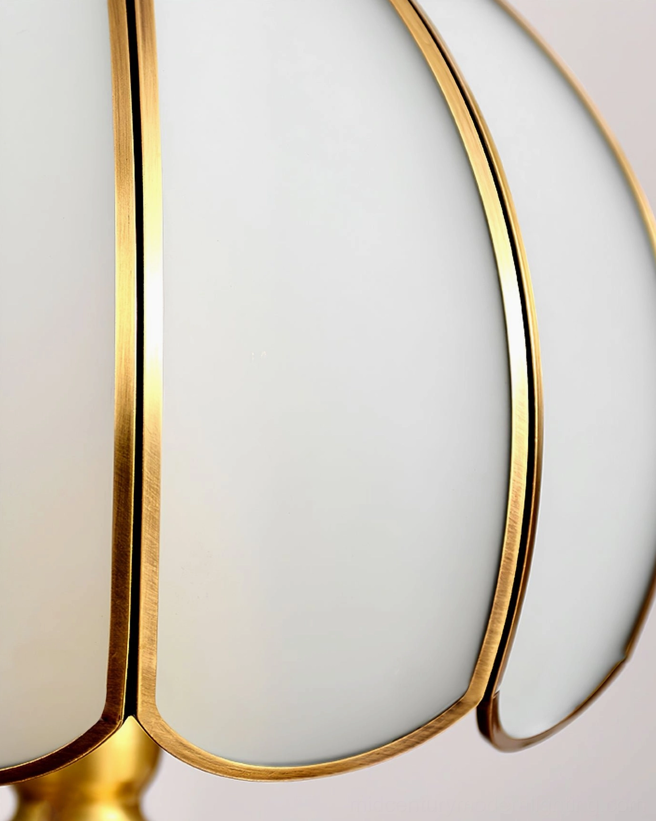 Brass table lamp with ribbed frosted glass shade angled view showing light diffusion effect