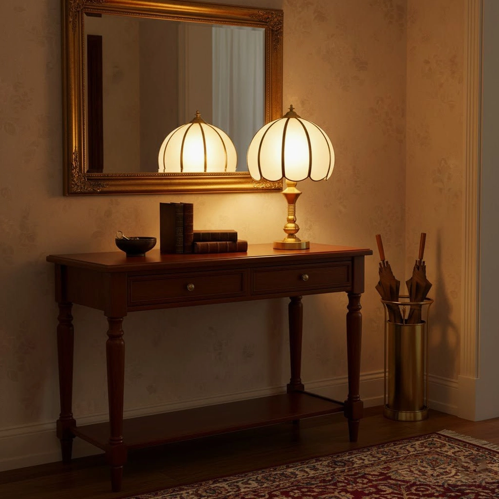 Brass table lamp on console table with gold framed mirror and dark wood furniture, vintage entryway styling