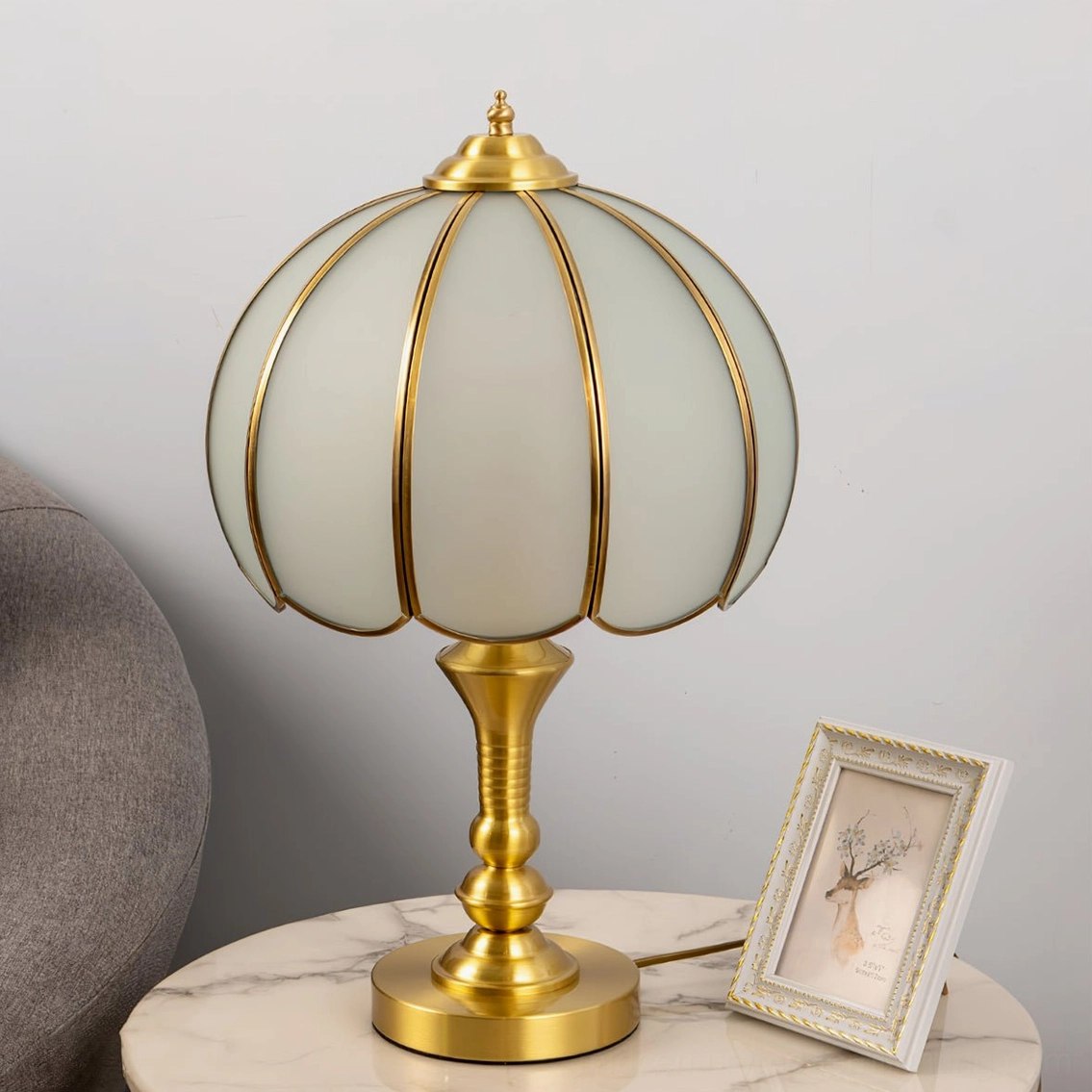 Frosted glass lamp shade detail with brass base, showing craftsmanship and warm light diffusion quality