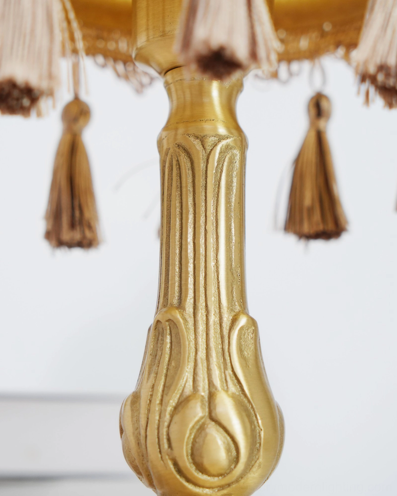 Vintage brass table lamp with tassel border accent on neutral background