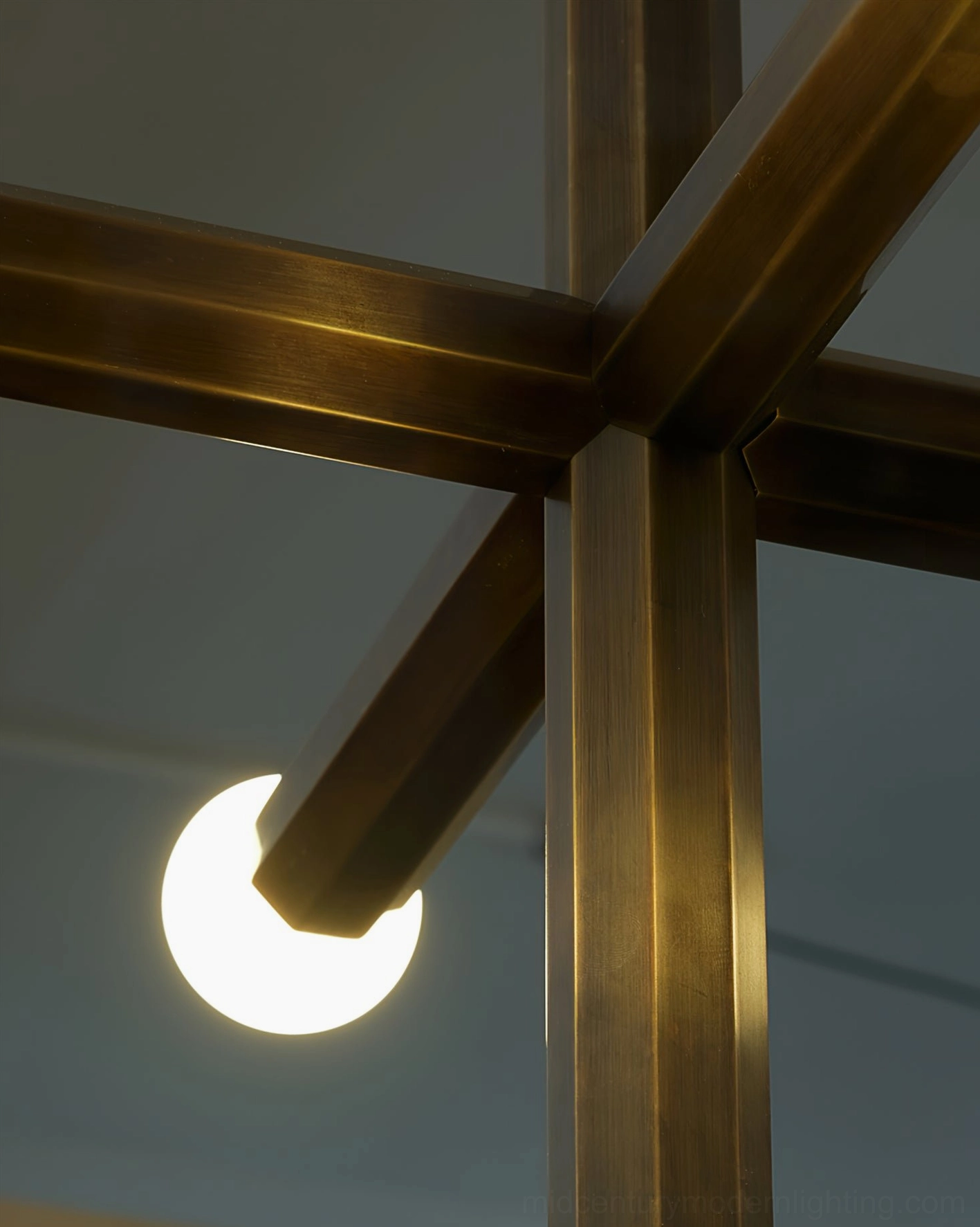 Close-up detail of aged brass metal joint and globe bulb in union pendant lamp