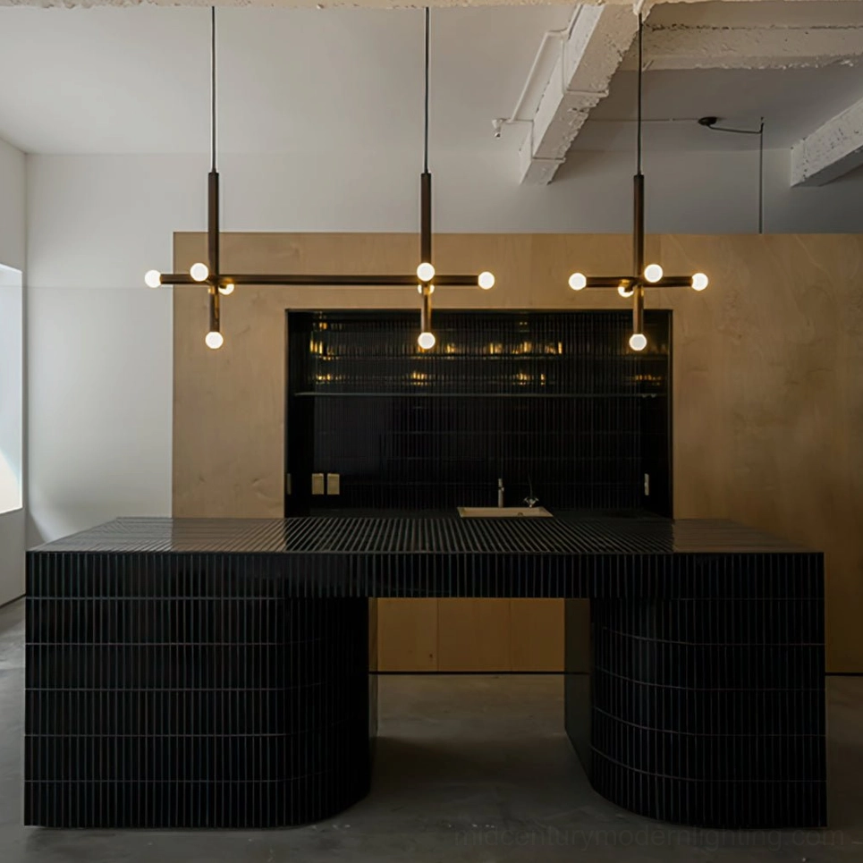 Linear brass pendant lamp fixture illuminated in modern kitchen island workspace