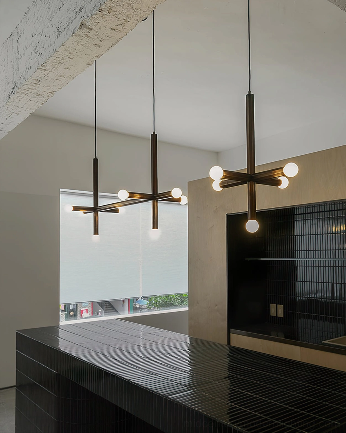 Matching brass pendant lamps in contemporary commercial kitchen space