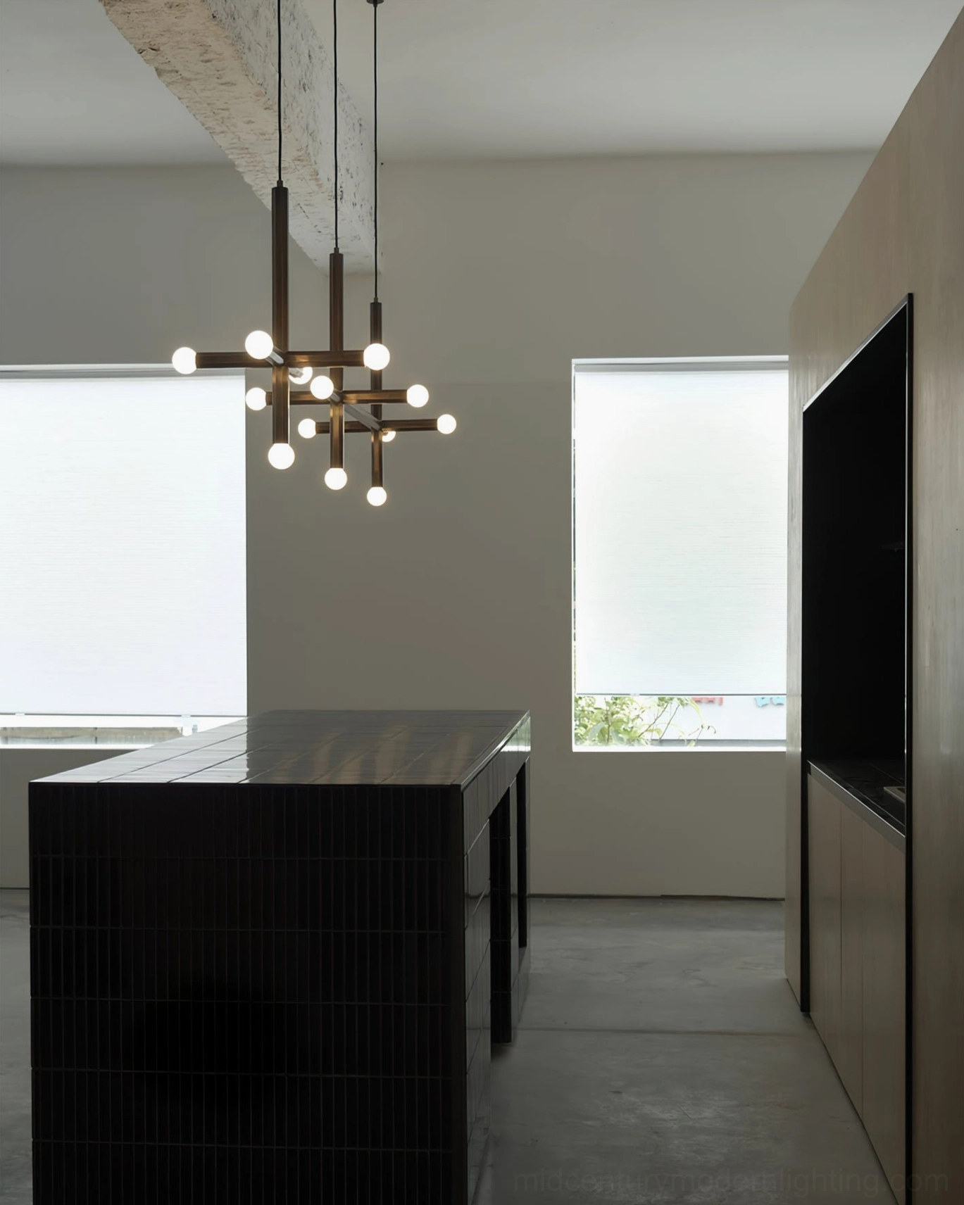 Multiple brass union pendant fixtures creating warm ambient lighting in office kitchen