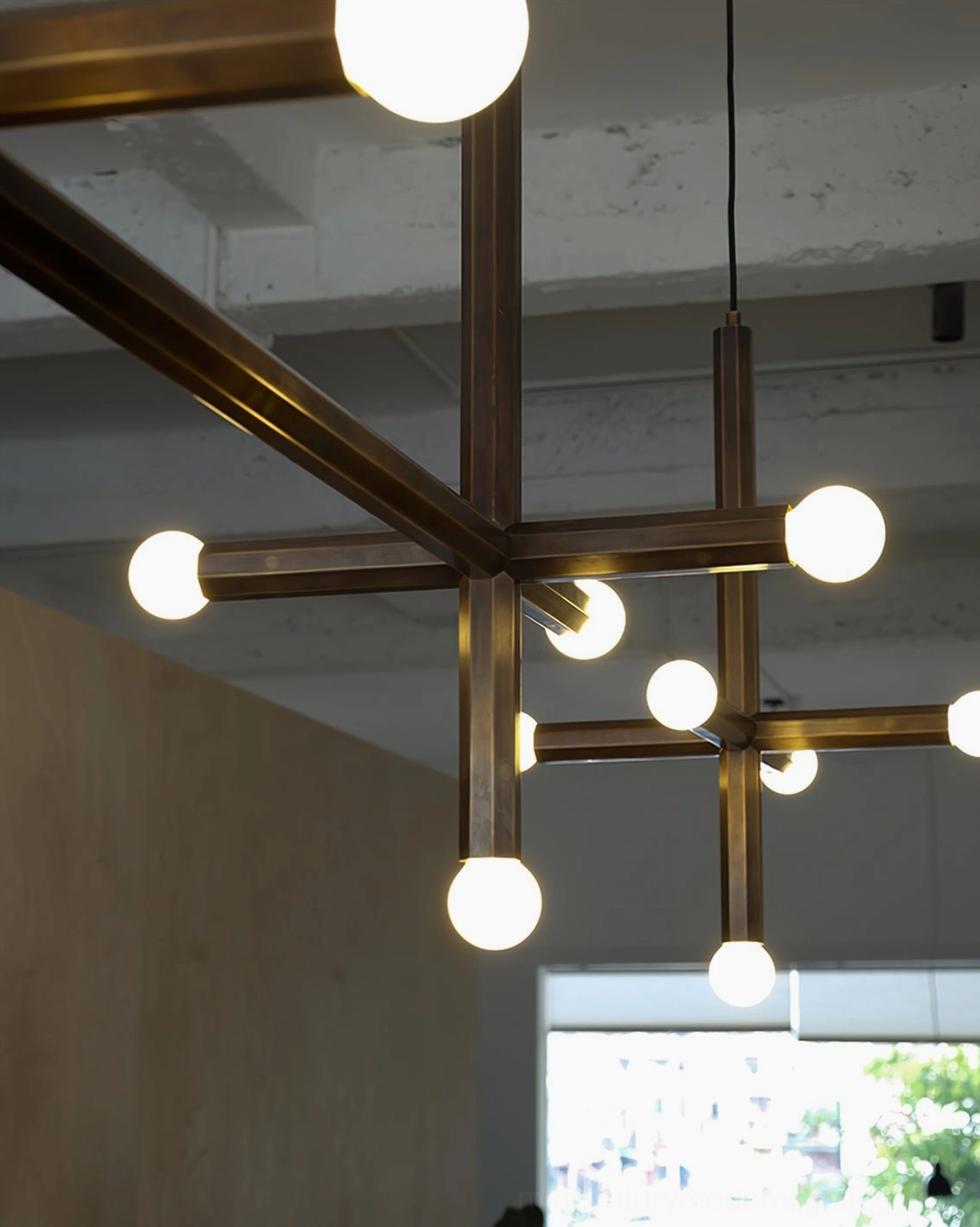 Warm glowing brass cross pendant lamp fixture showcasing aged patina finish
