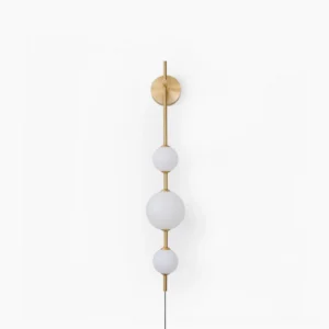 Vertical globe wall sconce in brass finish with three frosted white spheres, front profile view against studio backdrop