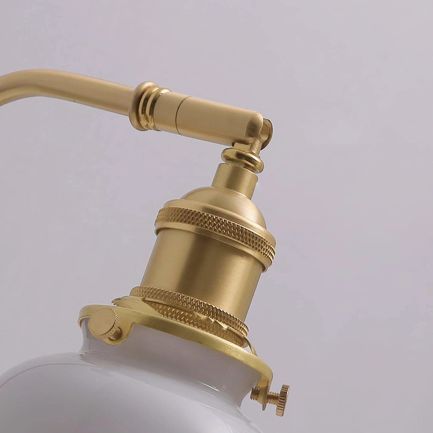 Brass and walnut wood mid-century modern wall sconce mounted on indoor wall with sheer curtain background