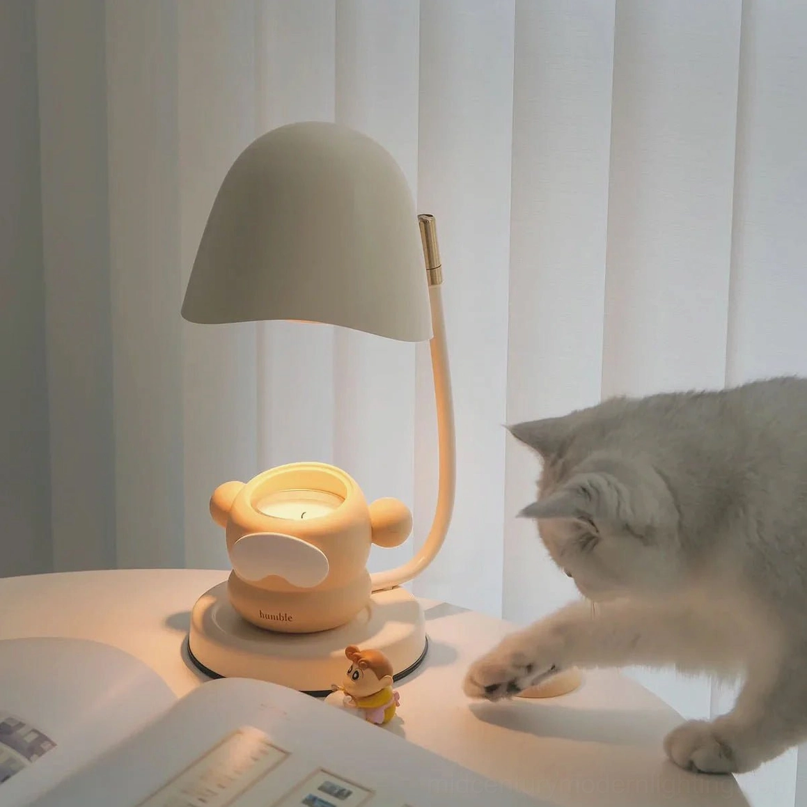 Beige Breez candle warming lamp on home desk with decorative monkey holder and casual tabletop styling