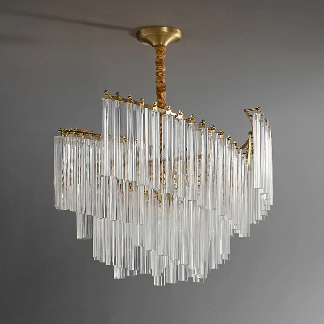Brinicle curved tiered crystal chandelier with brass frame studio front shot on grey background