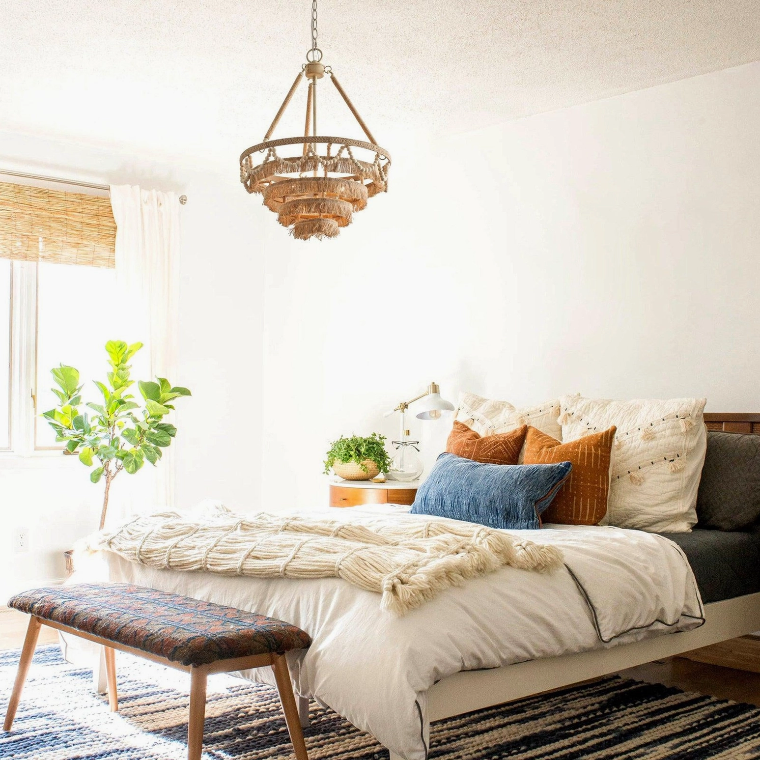 Bristol fringe chandelier in modern bedroom with soft bedding creating cozy boho coastal aesthetic