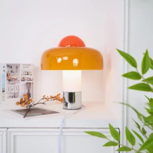 Brumbry mid-century modern table lamp styled on white dresser with green plant decor, three-quarter angle view