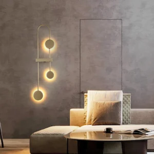 Three-pendant brushed gold modern wall lamp creating warm ambient lighting in luxury contemporary living room