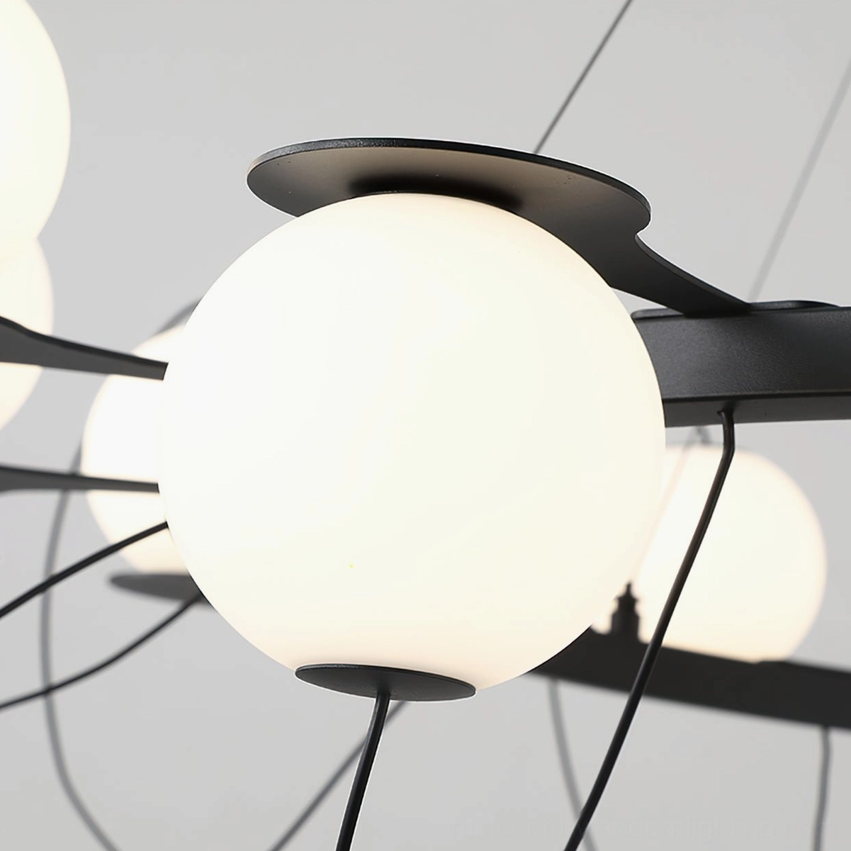 Close-up detail of frosted white glass globe with black metal magnetic mounting system
