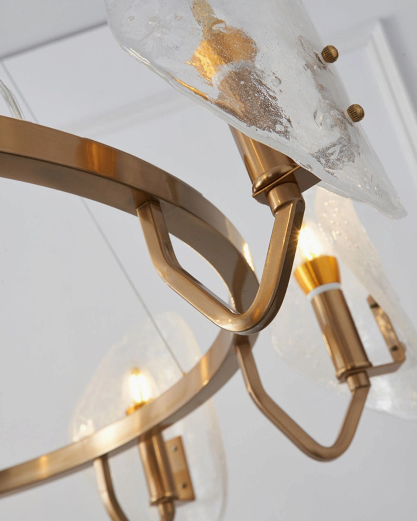 Macro close-up of brass gold mounting joints and textured bubble glass shade construction