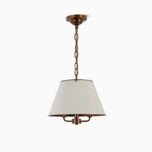Burdett brass pendant lamp with conical off-white fabric shade on white background, low-angle frontal view showing antique bronze hardware details