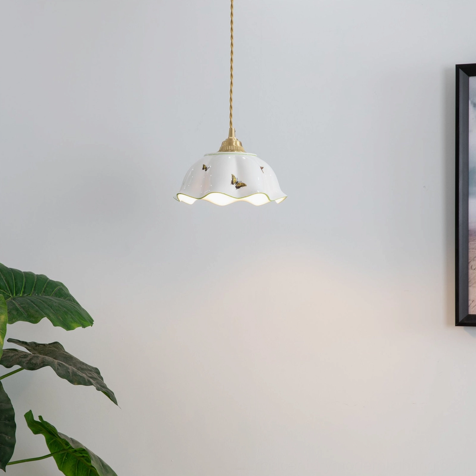 Glowing butterfly pendant light with soft warm illumination in minimalist interior with greenery