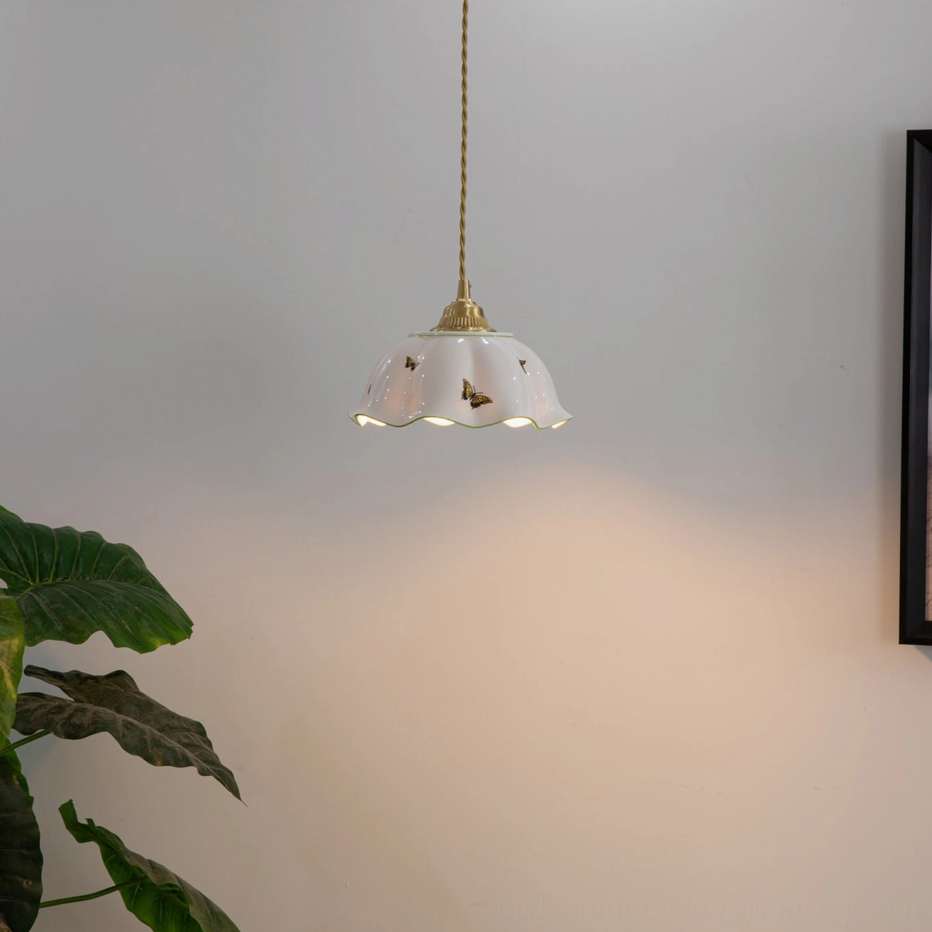 Illuminated butterfly ceramic pendant lamp with warm ambient glow in contemporary room setting