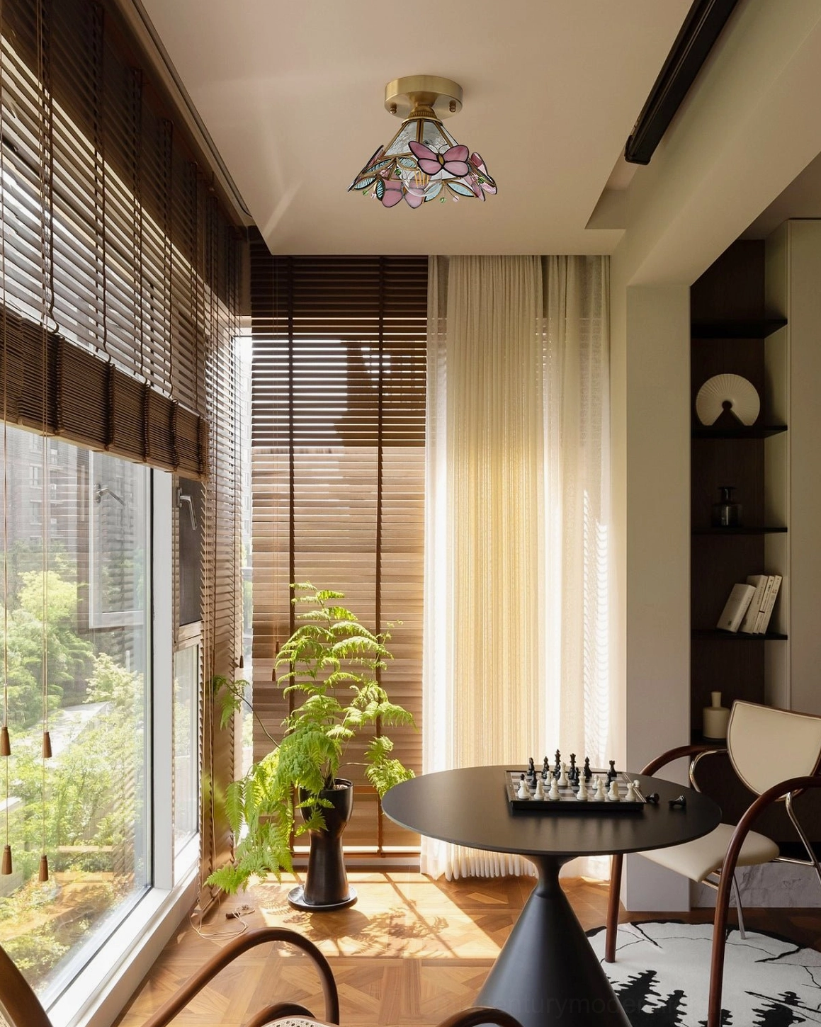 Stained glass butterfly light fixture in relaxed dining lounge with large windows and tropical home style