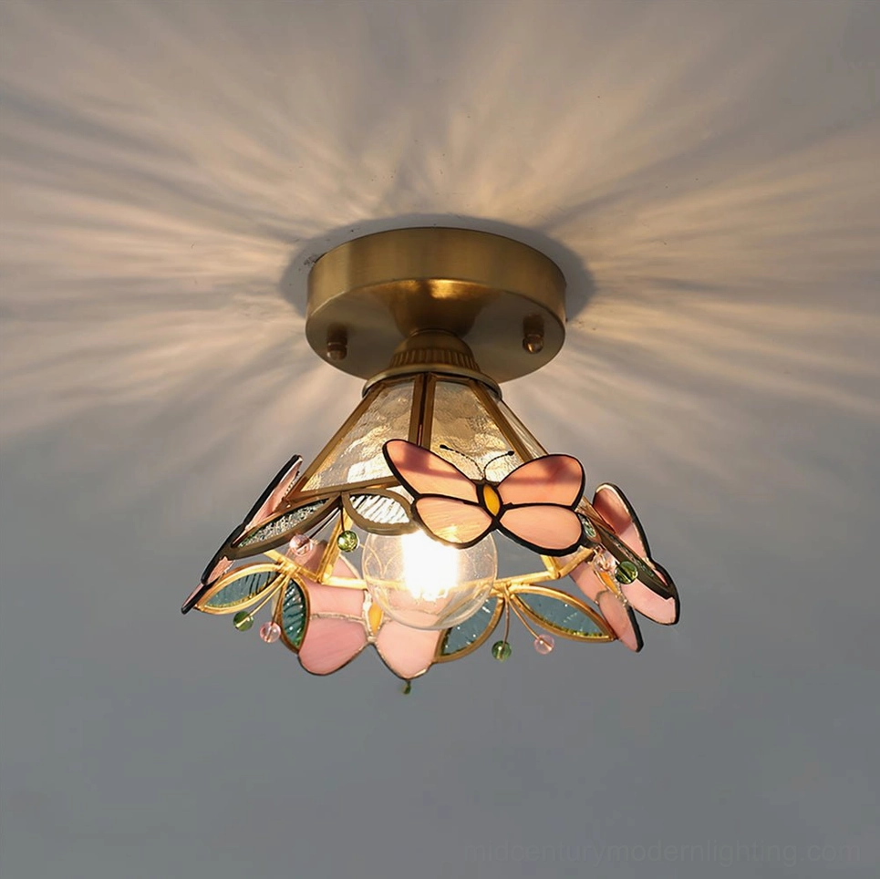 Bottom-up view of butterfly ceiling lamp emitting warm radial light pattern against gray wall