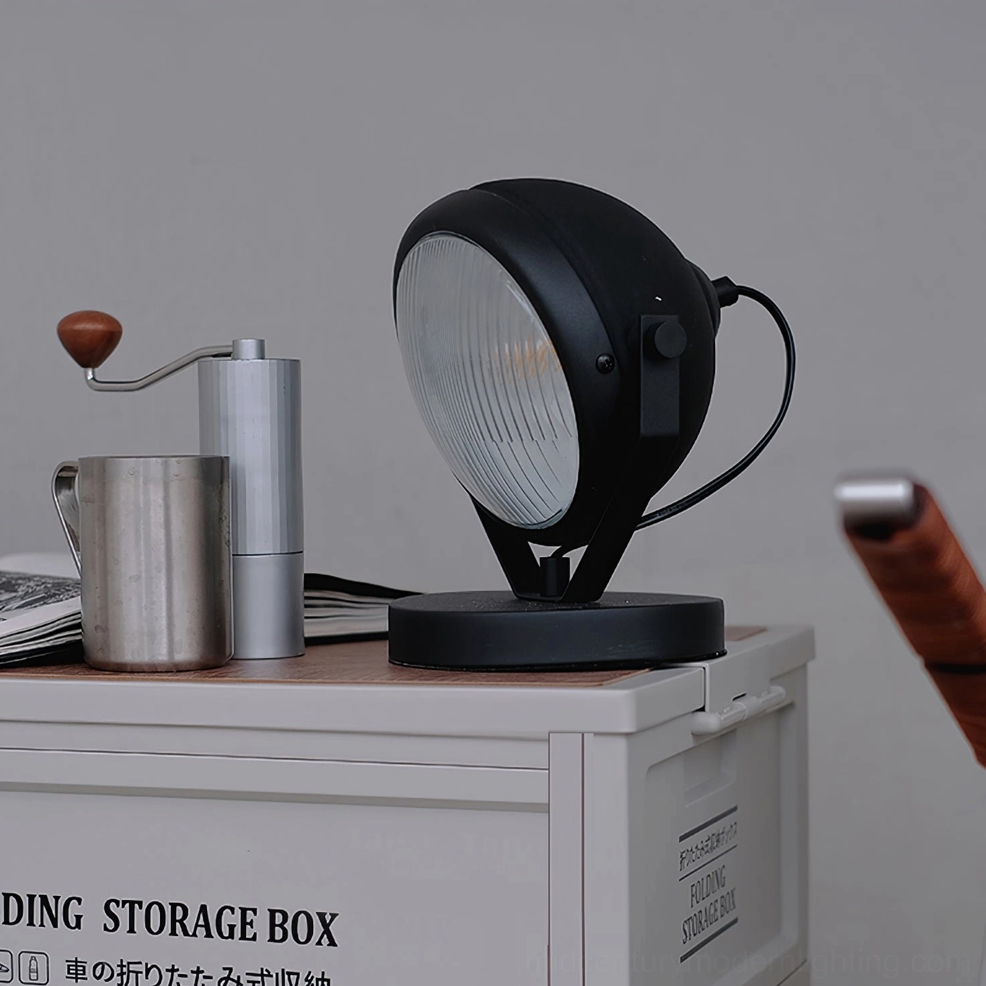 Cadillac matte black spotlight lamp close-up showing adjustable arm and metal finish on side table with coffee styling