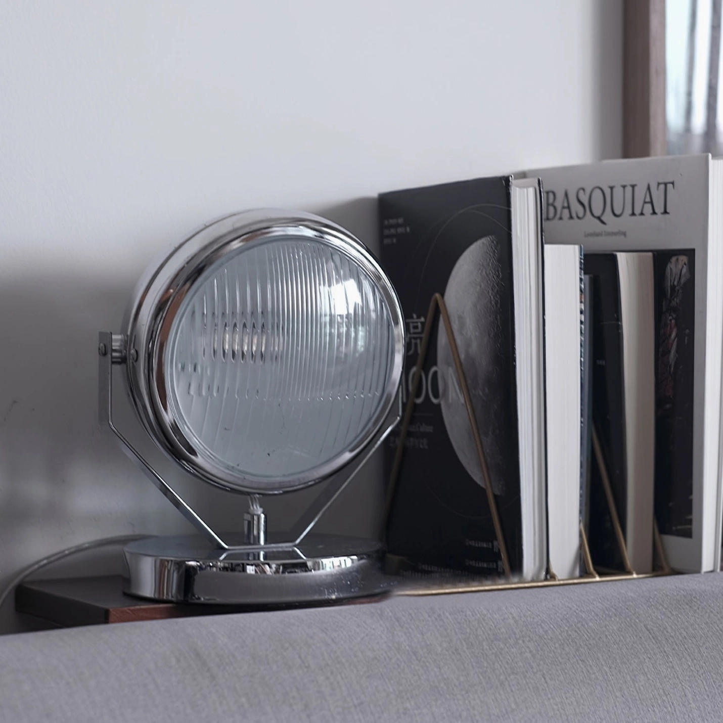 Cadillac chrome table lamp close-up detail shot on minimalist sofa table with contemporary art book styling