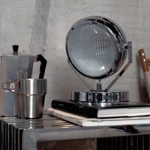 Chrome Cadillac table lamp styled on industrial side table with coffee set and vintage books - three-quarter perspective
