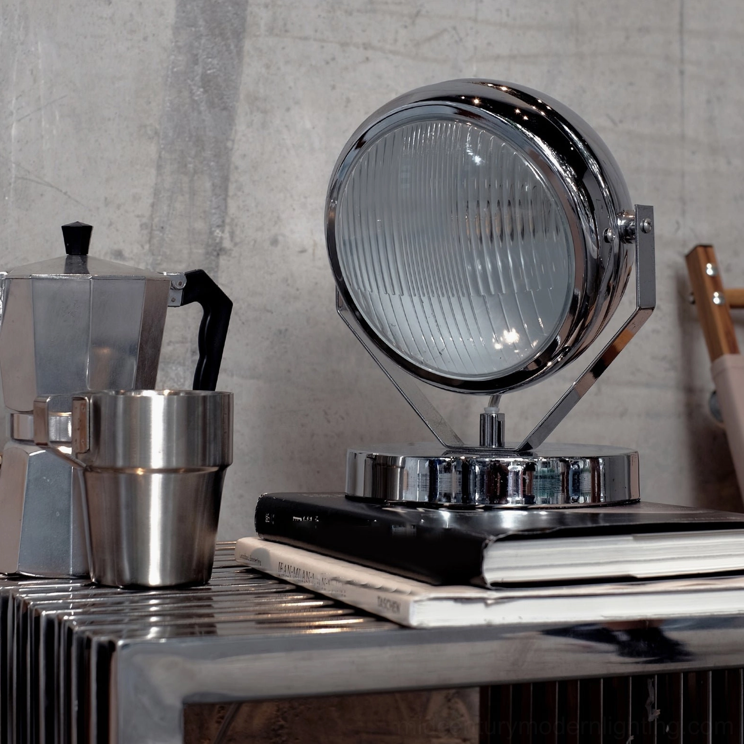 Chrome Cadillac table lamp styled on industrial side table with coffee set and vintage books - three-quarter perspective
