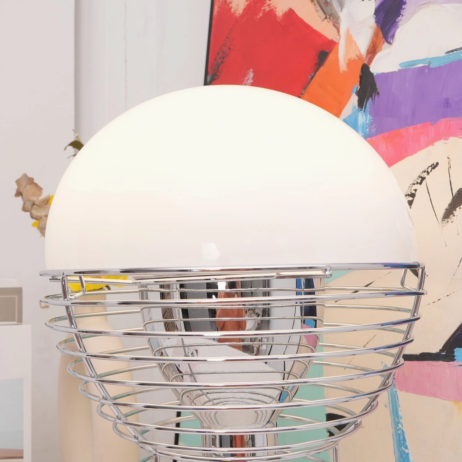 Modern wire cage table lamp wide low-angle shot showing dome shade and spiral base frame