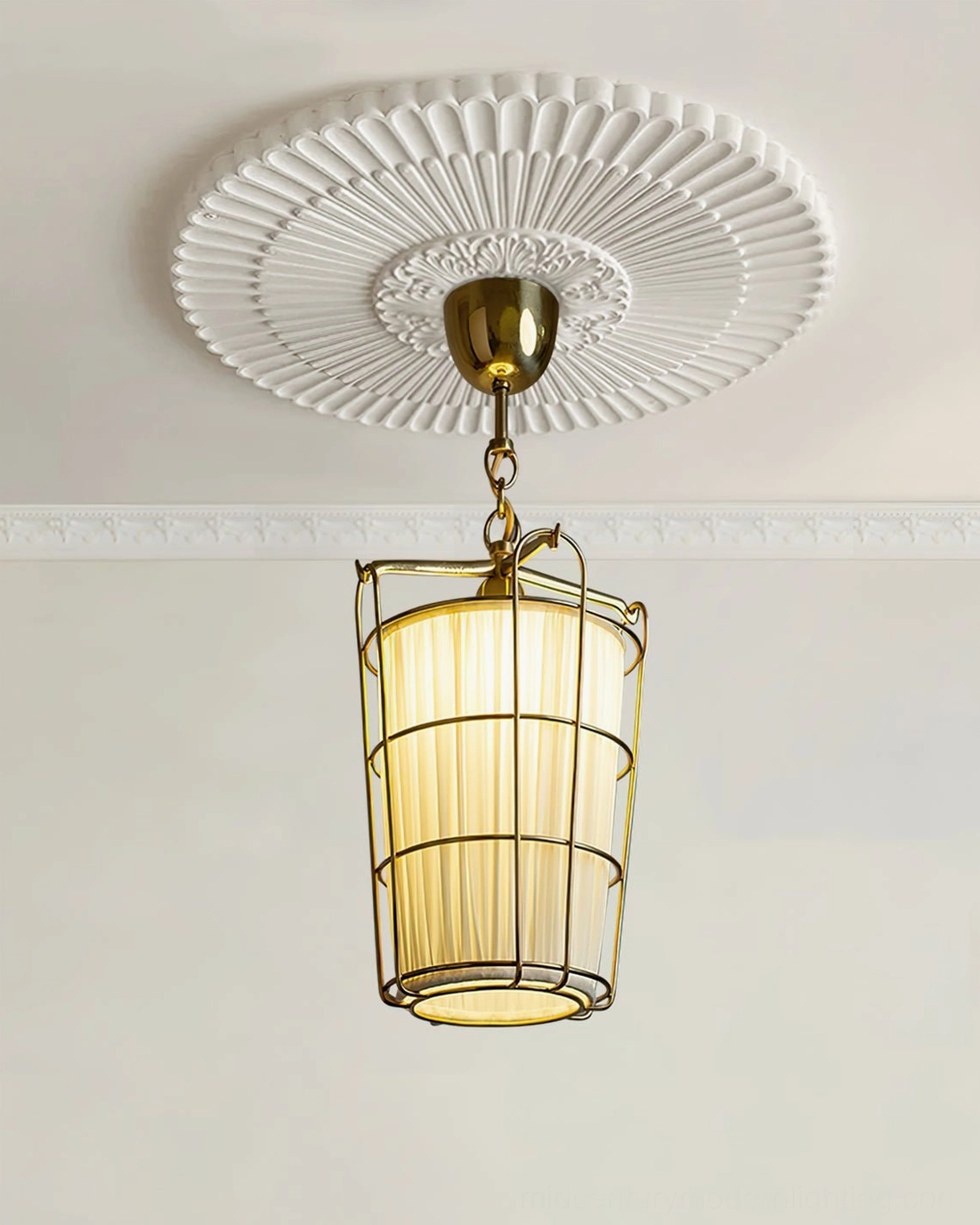 Low-angle view of illuminated caged chandelier with warm yellow LED lighting against embossed ceiling