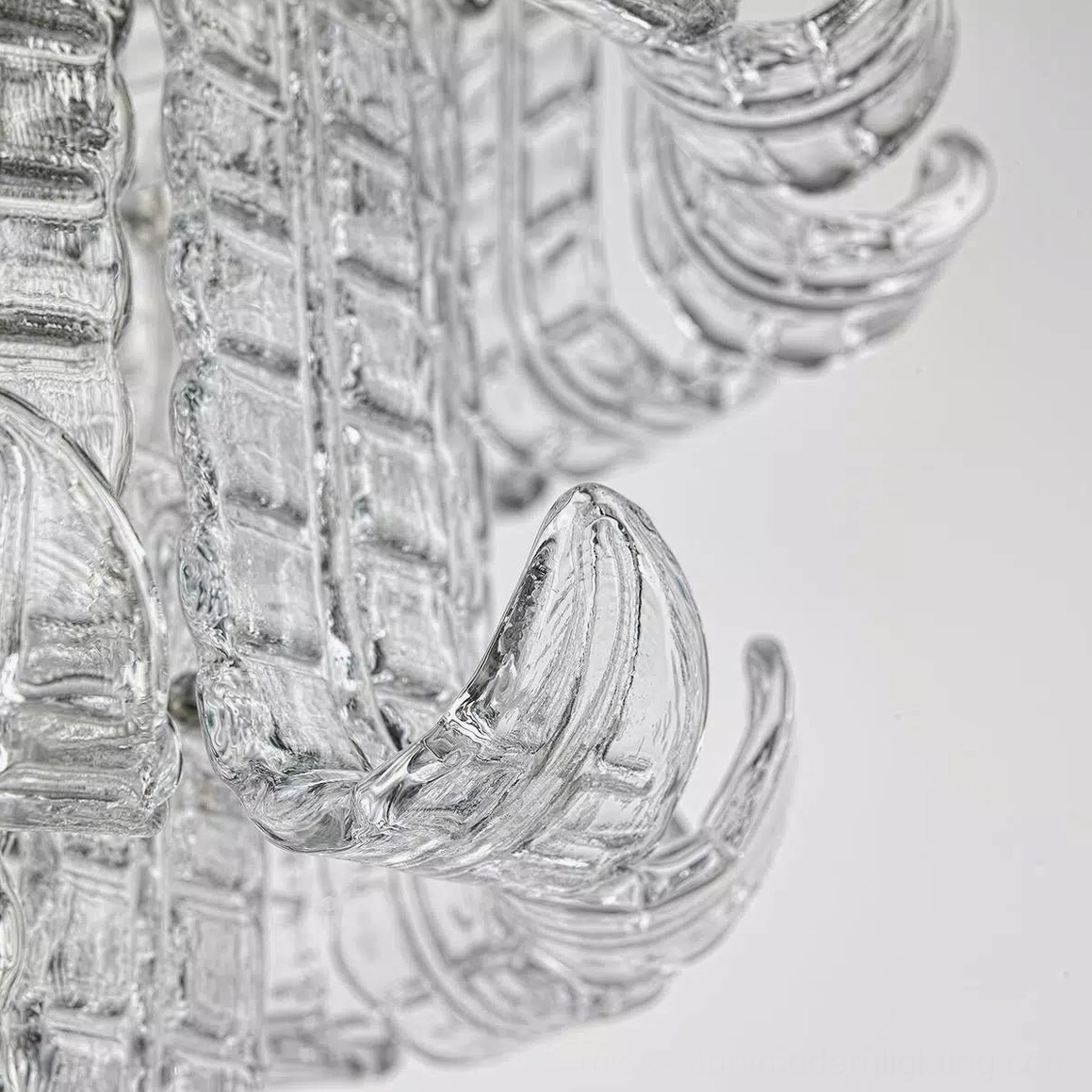 Calista chandelier individual glass component extreme close-up showing thick clear textured Murano glass claw shape and assembly joint