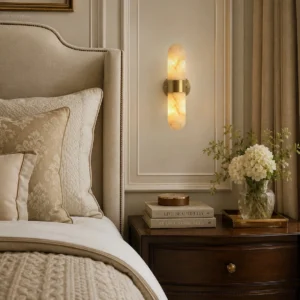 Pair of Calla alabaster sconces flanking wooden headboard in luxury master bedroom, bidirectional lighting