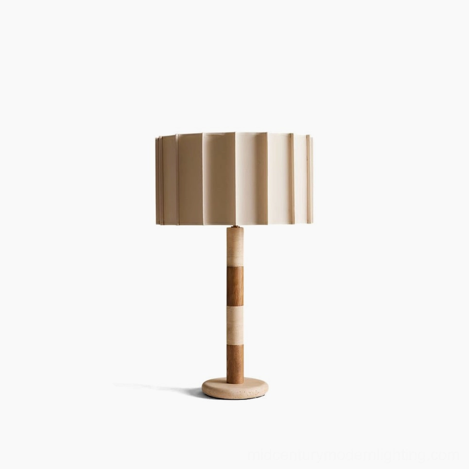 Calypso natural travertine table lamp with pleated linen shade, front studio view showing sculptural stacked stone and wood base design