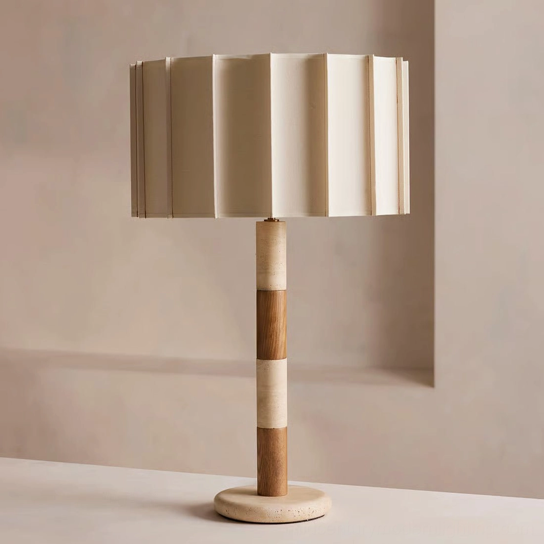 Calypso travertine table lamp three-quarter angle on interior tabletop displaying segmented travertine and walnut wood construction details