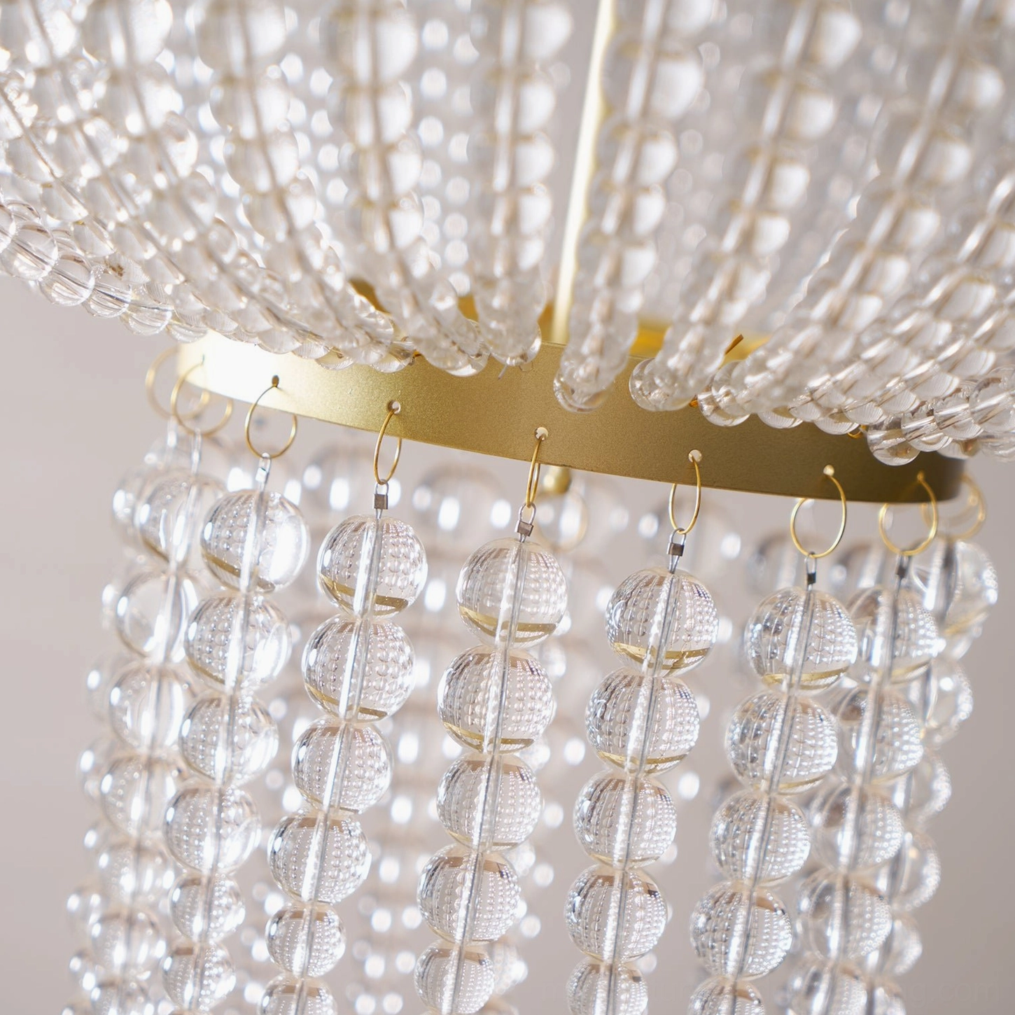 Campana crystal chandelier illuminated showing warm light glow through faceted crystal glass beads