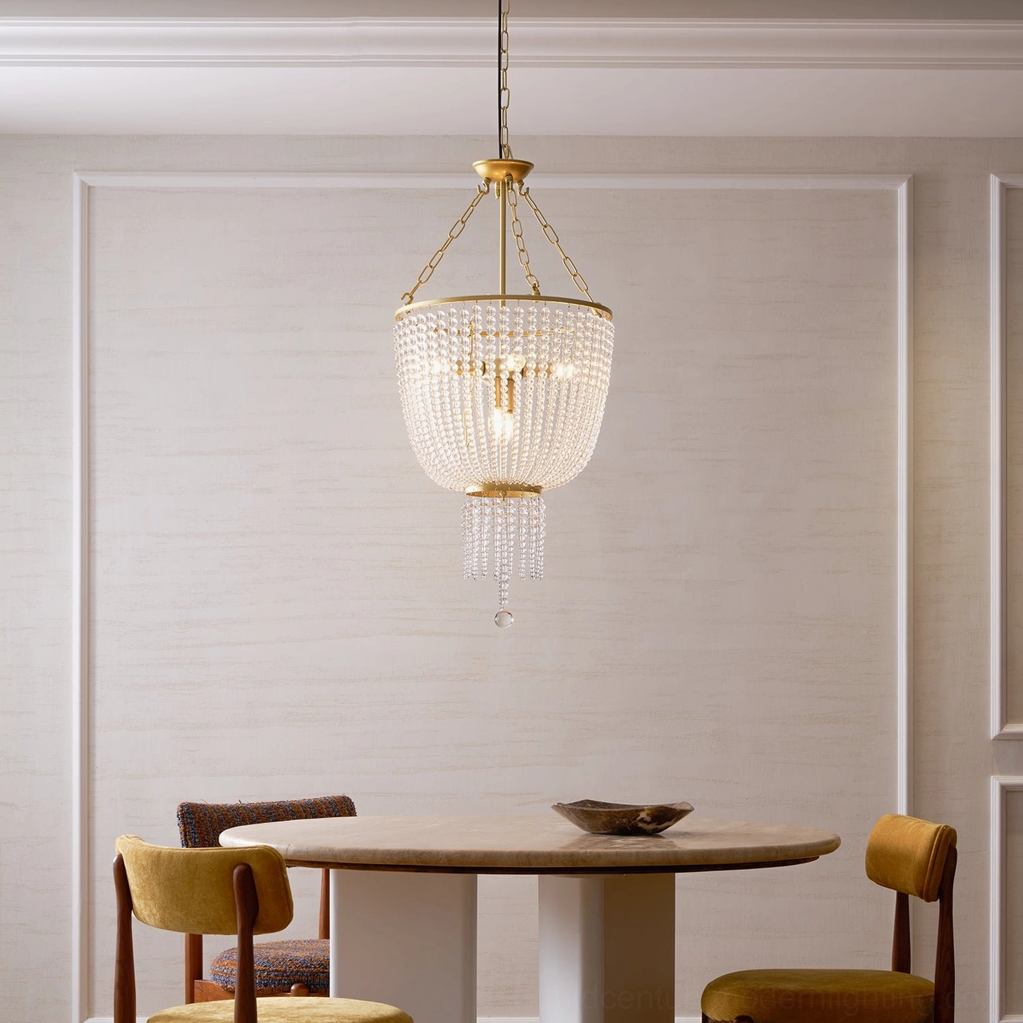 Minimalist dining nook with Campana crystal chandelier and mustard yellow upholstered dining chairs
