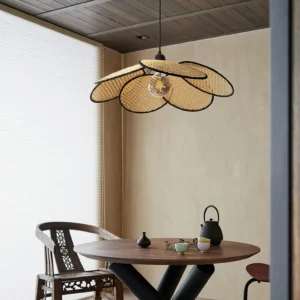 Rattan petal pendant light hanging above minimalist wooden dining table in warm bohemian dining space with natural wood furnishings