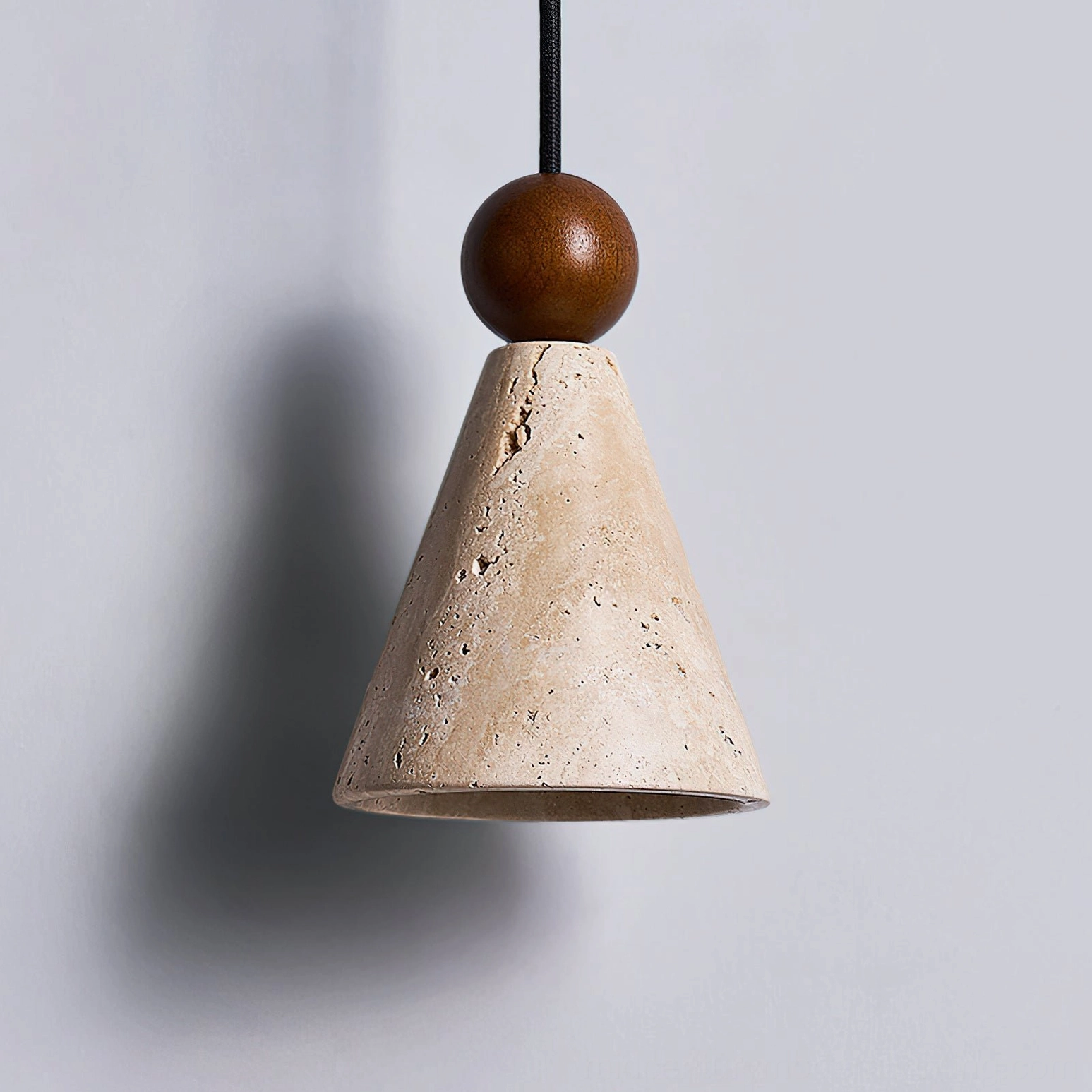 Close-up detail of Canyon travertine pendant showing natural stone veining and walnut sphere bead