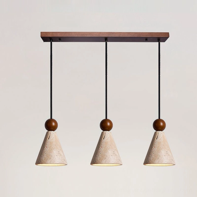 Three-light linear travertine pendant row installation above long kitchen island countertop