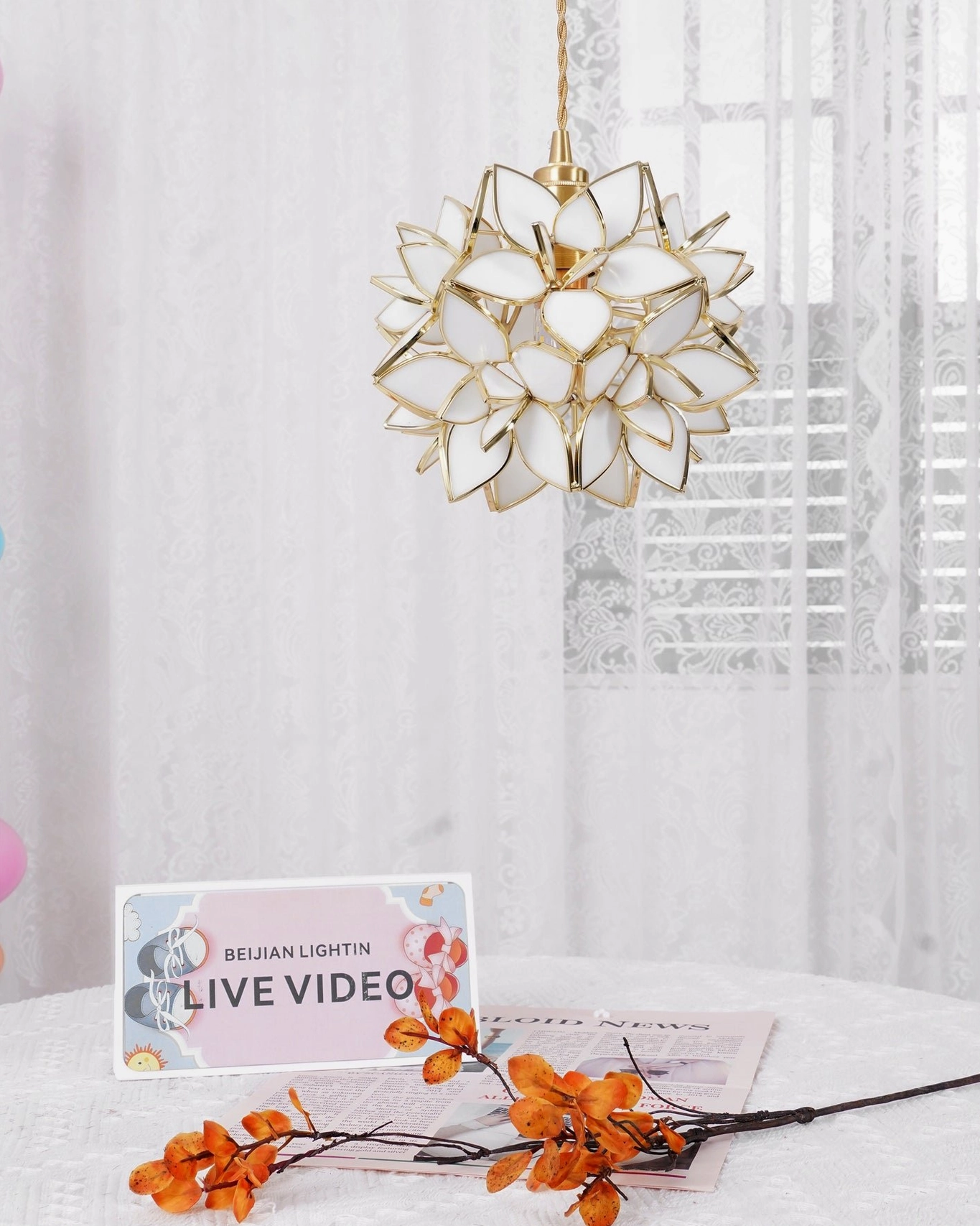 Capiz pendant lamp showing gold brass fixture and translucent glass petal construction from front angle