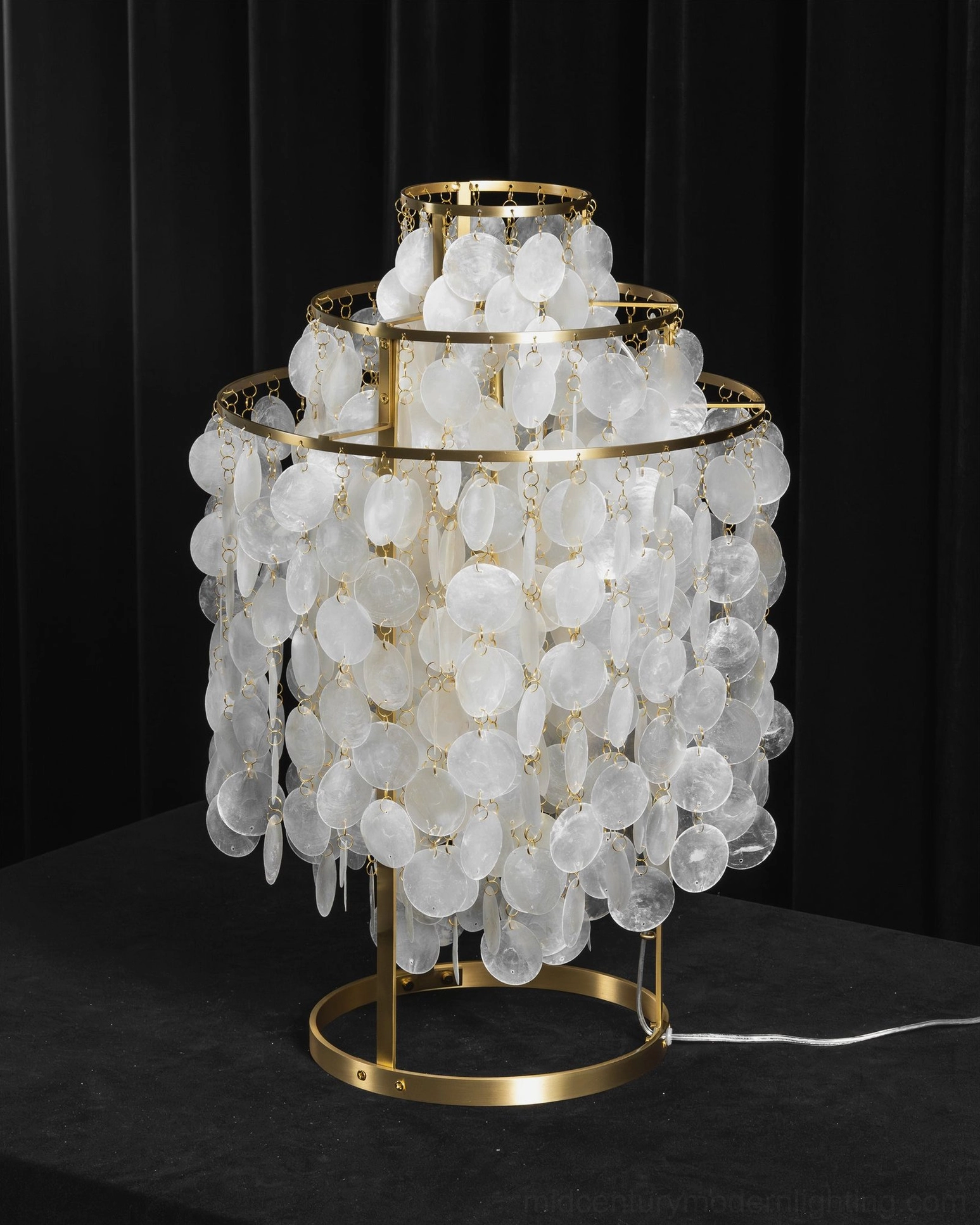 Modern capiz shell table lamp unlit on dark studio background showing shell detail structure