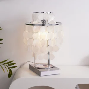 Contemporary capiz shell pendant light in minimalist home setting with book and green plant